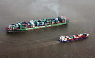 Two ships loaded with containers travel on the sea