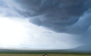 Sturm Wolken über Wiesen und Bergen